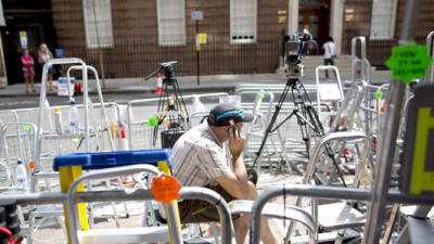 A journalist speals on his mobile phone as he sits amid media stepladders outside the Lindo Wing of St Mary's hospital in London, on July 13, 2013, where Prince William and his wife Catherine's baby will be born. Britain's royal family and the world's media are on tenterhooks awaiting the birth of Prince William and wife Catherine's first child, a baby who will one day be king or queen of Britain and a diverse group of commonwealth countries. AFP PHOTO / JUSTIN TALLIS