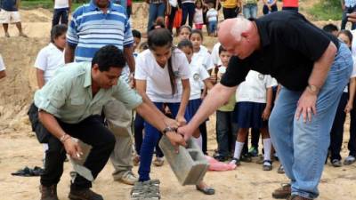 El alcalde Delbin Salgado, Charles Newman, de Escuelas para Niños, y escolares colocan el primer bloque de la obra.