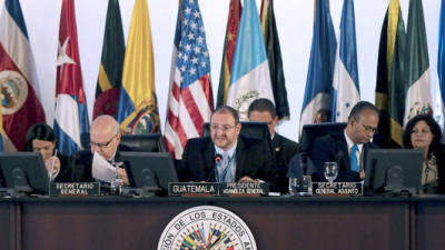 Guatemalan Minister of Foreign Affairs Luis Fernando Carrera (C) speaks during the 1st meeting of the XLIII General Assembly of the Organization of American States, flanked by OAS Secretary General Chilean Jose Miguel Insulza (L) and OAS Deputyt Secretary General, Ambassador Albert Ramdin, in Antigua Guatemala, 50 km southwest of Guatemala City on June 5, 2013. AFP PHOTO/Johan ORDONEZ
