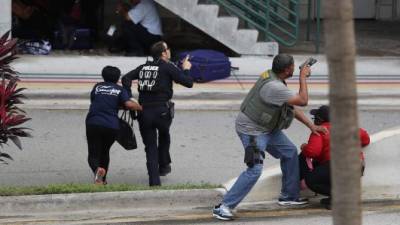 Agentes de seguridad tratan de sacar a las personas que quedaron atrapadas en las inmediaciones del lugar en el que se produjo el tiroteo.