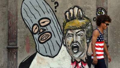 Fotografía de un grafiti de un encapuchado sosteniendo la cabeza decapitada del presidente estadounidense, Donald Trump, este 29 de junio de 2017, en la pared de una transitada calle de La Habana Vieja, en La Habana (Cuba). EFE