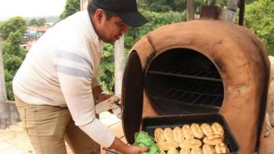 Un hombre saca del horno 'tatakua' unas chipas, el tradicional panecillo de la gastronomía guaraní, hoy, martes 27 de marzo de 2018, en el popular barrio de 'La Chacarita', en Asunción (Paraguay), durante el habitual 'chipa apó' (cocinar chipa, en idioma guaraní) previo al ayuno de la Semana Santa. EFE