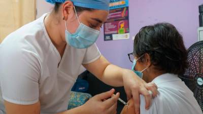 Biológico. Una enfermera aplica una vacuna anticovid a una señora.