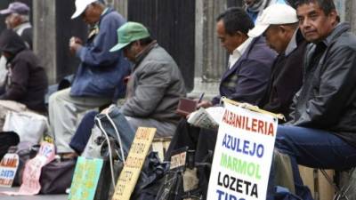 Un grupo de desempleados se las ingenian en una acera para ofrecer servicios de albañilería. La Cepal y OIT proponen una diversificación productiva en Latinoamérica.