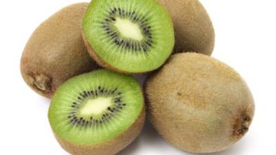 close up portrait of a girl putting a kiwi slice in her mouth she's about to bite and eat because she enjoys the flavour and she knows this is very healthy because of the vitamins