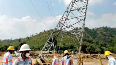 Personal trabaja en la reconexión de las líneas de distribución en Atlántida.