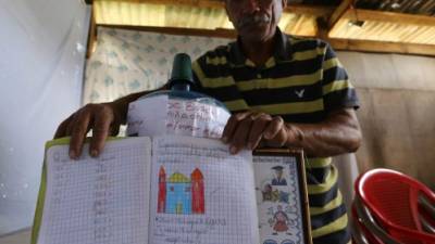 Familiares de Orlin muestran los cuadernos del pequeño que fue hallado asesiando muerto el domingo.