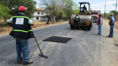 Un grupo de obreros trabaja en la reparación de tramos de la carretera al sur de Honduras.