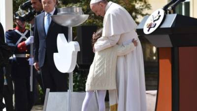 Momentos en que una niña abraza al Papa Francisco, le acompaña el presidente Juan Manuel Santos.