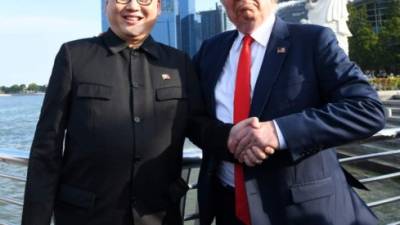 El imitador del líder norcoreano Kim Jong Un, el imitador Howard X (L) y el imitador de Donald Trump Dennis Alan (R) reaccionan en el parque Merlion en Singapur el 8 de junio de 2018.