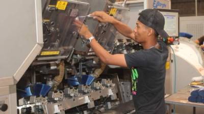 Un obrero revisa una máquina en una empresa en el municipio de Choloma, Cortés.