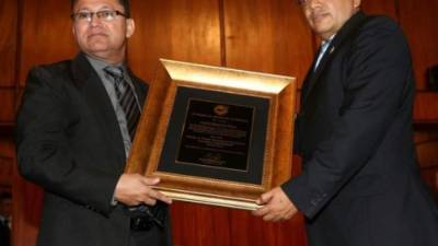 El periodista hondureño y director ejecutivo de Diario El Heraldo, Carlos Mauricio Flores, (izquierda) recibe el premio Álvaro Contreras de manos del presidente del Colegio de Periodistas de Honduras, Eduin Romero.