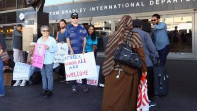 La gente recibe a lols viajeros en el aeropuerto de Los Ángeles en medio de las protestas por el decreto de Trump que prohibe la entrada a ciudadanos de siete países musulmanes.