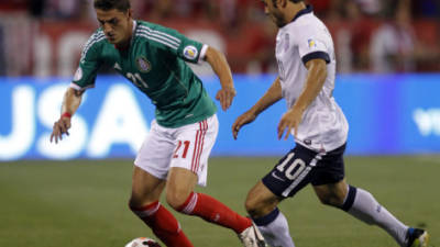 El estadounidense Landon Donovan pelea el balón con el defensor azteca Hiram Mier durante el partido que ambas selecciones empatan 0-0 al cierre del primer tiempo.