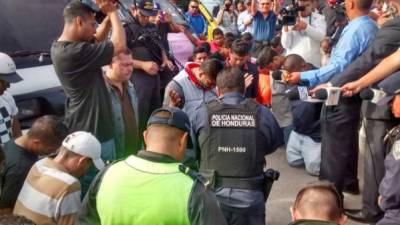 Un miembro de la Policía Nacional de Honduras dialoga con los manifestantes y realiza una oración.