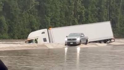 Un hombre intenta escapar de un tráiler arrastrado por las corrientes en las inundaciones en el sur de Texas.