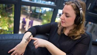 Una mujer prueba el dispositivo parecido a un tatuaje en su brazo.