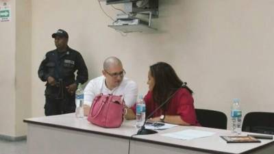 El imputado Rigoberto Paredes dialoga con una defensora legal en la sala de juicios orales de Tegucigalpa.