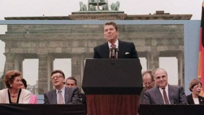 Foto de archivo tomada el 12 de junio de 1987 del entonces presidente estadounidense, Ronald Reagan (c), mientras da un discurso en el lado occidental del Muro de Berlín acompañado por el ex canciller alemán Helmut Kohl (a la derecha de Reagan) delante de la Puerta de Brandemburgo en Berlín (Alemania). EFE