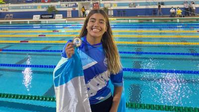 La sirena Michell Ramírez con la medalla de oro y la bandera de Honduras tras lograr su primera presea.