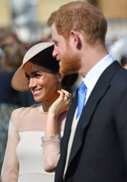 Britain's Prince Harry, Duke of Sussex (R), and his new wife, Britain's Meghan, Duchess of Sussex, attend the Prince of Wales's 70th Birthday Garden Party at Buckingham Palace in London on May 22, 2018.<br/>The Prince of Wales and The Duchess of Cornwall hosted a Garden Party to celebrate the work of The Prince's Charities in the year of Prince Charles's 70th Birthday. / AFP PHOTO / POOL / Dominic Lipinski