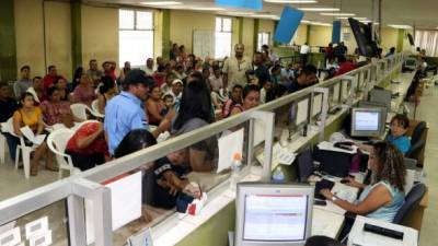 Contribuyentes hacen fila en la oficina de la Dirección Ejecutiva de Ingresos (DEI) en San Pedro Sula. Foto: Amílcar Izaguirre