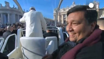 El papa Francisco (d) invita a subir al 'papamóvil' al párroco argentino Fabián Baéz (i) antes de la audiencia general de los miércoles en la plaza de San Pedro del Vaticano. Foto: Youtube