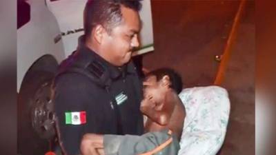 Un policía mexicano carga al menor que fue maltratado por su padre.
