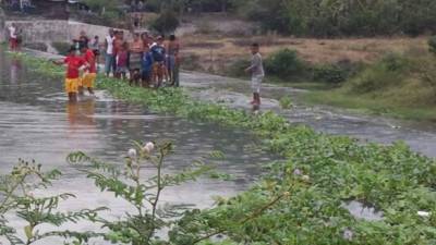 Los bomberiles cuando rescataban el cadáver en el río Choloma.