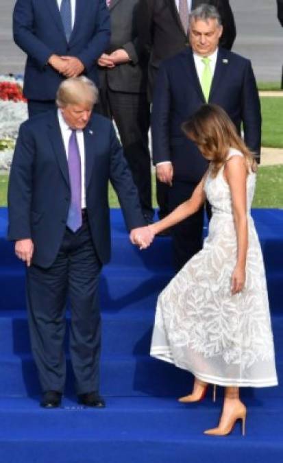 Estuvo pendiente de su esposa en cada momento, en esta foto la toma de la mano mientras se preparan para posar en una foto grupal antes de la cena.