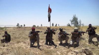 Miembros de las fuerzas de seguridad iraquíes y milicianos chiíes posan con sus armas en una zona al sur de Biyi, al norte de Bagdad, Irak. EFE/Archivo