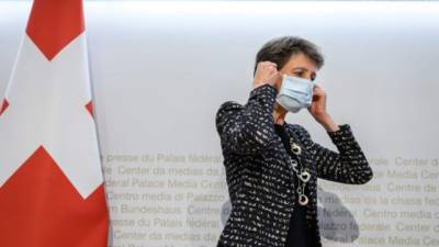 La presidenta suiza Simonetta Sommaruga se pone una mascarilla protectora después de una conferencia de prensa anunciando nuevas medidas contra el coronavirus el 18 de octubre de 2020 en Berna.