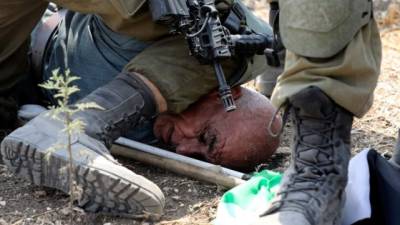 Periodistas documentaron en videos y fotografías la acción en la que el soldado inmovilizó al palestino. Foto: AFP