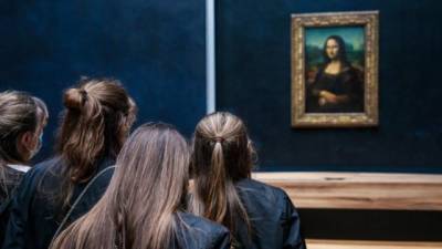 Un grupo de jóvenes contempla el original de La Gioconda en el Museo de Louvre de París.