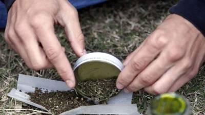 Una persona arma un cigarro de marihuana.