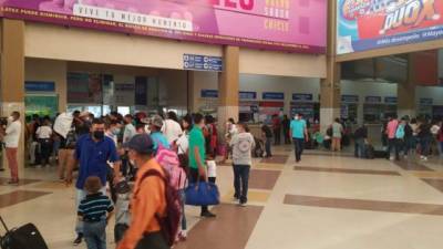 Personas hacen fila en la terminal de San Pedro Sula para comprar sus pasajes.