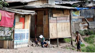 Un hombre cuida de sus hijos en un asentamiento cercano al crematorio municipal, al oeste de Tegucigalpa (Honduras).