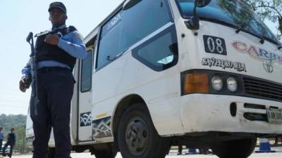 El rubro del transporte es sufre a diario la extorsión. Un policía resguarda un bus que fue tiroteado por extorsionadores.