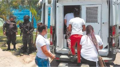 Cuatro de las 14 reclusas suben a un vehículo para ser enviadas a otros centros penales.