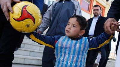 El niño afgano disfrutó lucir con la camiseta del Barcelona en un campo de fútbol.