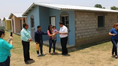 Una pareja recibe alegre la llave de su vivienda de manos del gobernador de Yoro, Gabriel Rubí. Foto: Efraín V. Molina.