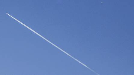 Un avión comercial (i) vuela por debajo del globo espía chino (d) detectado en el espacio aéreo estadounidense, este sábado en Charlotte (Estados Unidos).