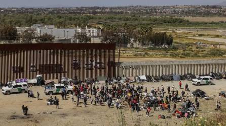 Decenas de migrantes reunidos en un punto fronterizo entre México y Estados Unidos.