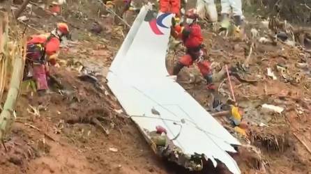 Equipos de rescate con una pieza del fuselaje mientras continúan su búsqueda en el lugar donde el avión de pasajeros de China Eastern se estrelló contra la ladera de una montaña cerca de Ciudad de Wuzhou.