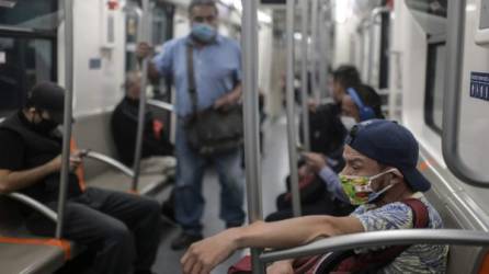 Los viajeros usan mascarillas como medida preventiva contra la propagación del nuevo coronavirus mientras viajan en el metro en la Ciudad de México. Foto AFP