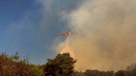 Un avión lanza este martes agua a las llamas de un incendio forestal en la isla de Rodas (Grecia).