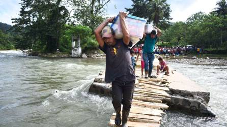 Poblaciones cercanas a Paso Viejo trasladando sobre sus hombros las cajas cargadas de alimentos para moverse a más de dos horas rumbo a sus comunidades.