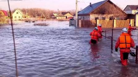 Esta foto tomada de un vídeo publicado por el Ministerio de Situaciones de Emergencia de Rusia el 6 de abril de 2024 muestra a los rescatistas caminando por una calle inundada en su camino para evacuar a los residentes en la ciudad de Orsk, región de Orenburg, al sureste del extremo sur del Montes Urales.