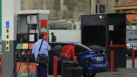 Fotografía muestra a un bombero de una estación gasolinera cargar combustible a un vehículo en Tegucigalpa, Honduras.