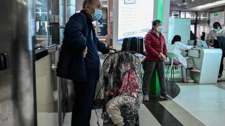 Los niños y sus padres esperan en un área ambulatoria de un hospital infantil en Beijing el 23 de noviembre de 2023.